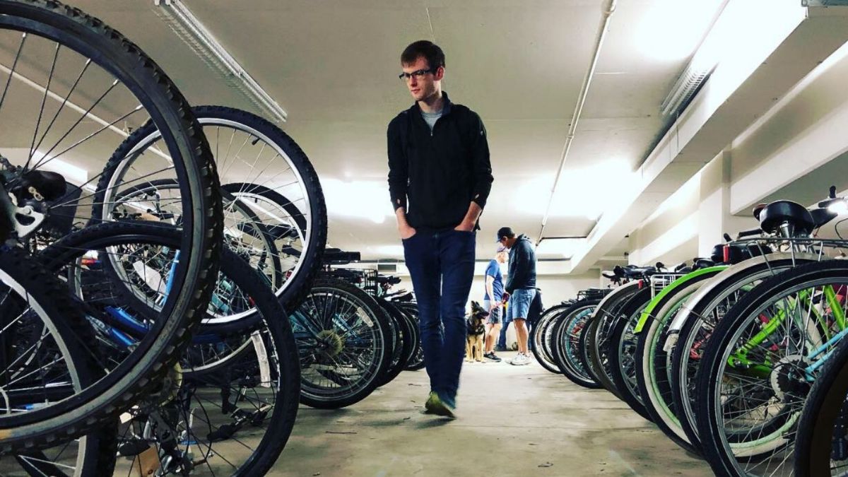 person walking through inventory of abandoned bikes