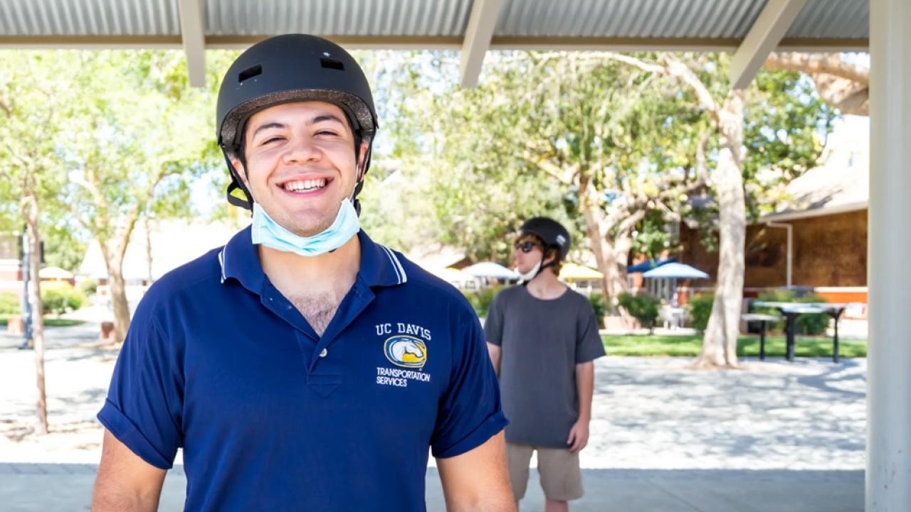 Student poses wearing a helmet and mask.